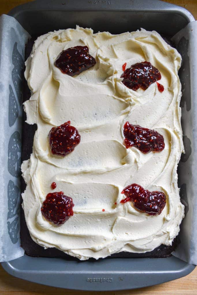 raspberry jam dolloped onto vanilla frosting