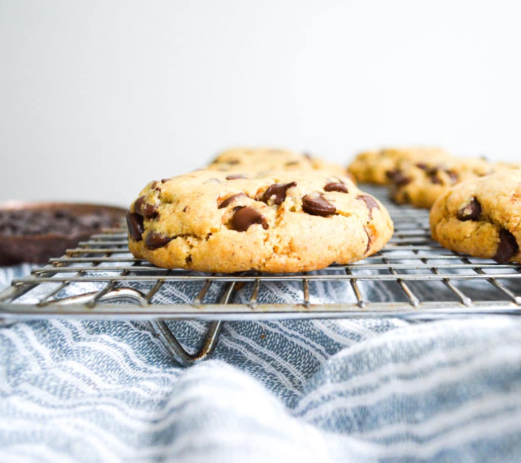 Close up of a thick chocolate chip cookie on a cooling rack
