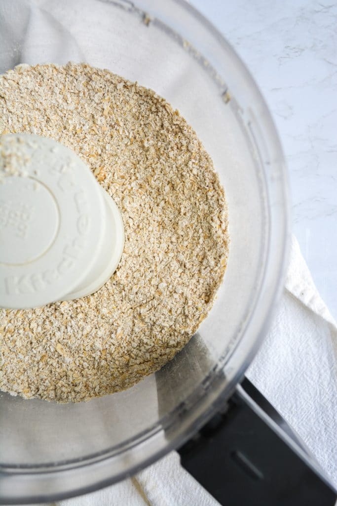 Close up of ground oats in a food processor