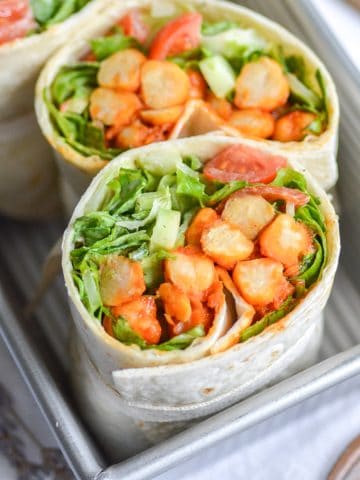 Vegan Buffalo Chickpea Wrap Sliced in half and stacked in a loaf pan.