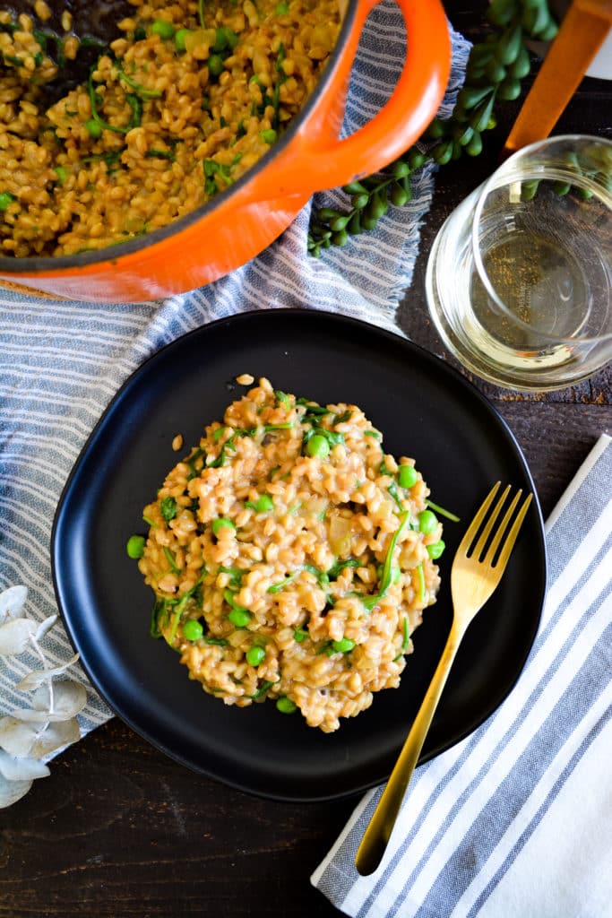 a plate of farroto with peas and arugula