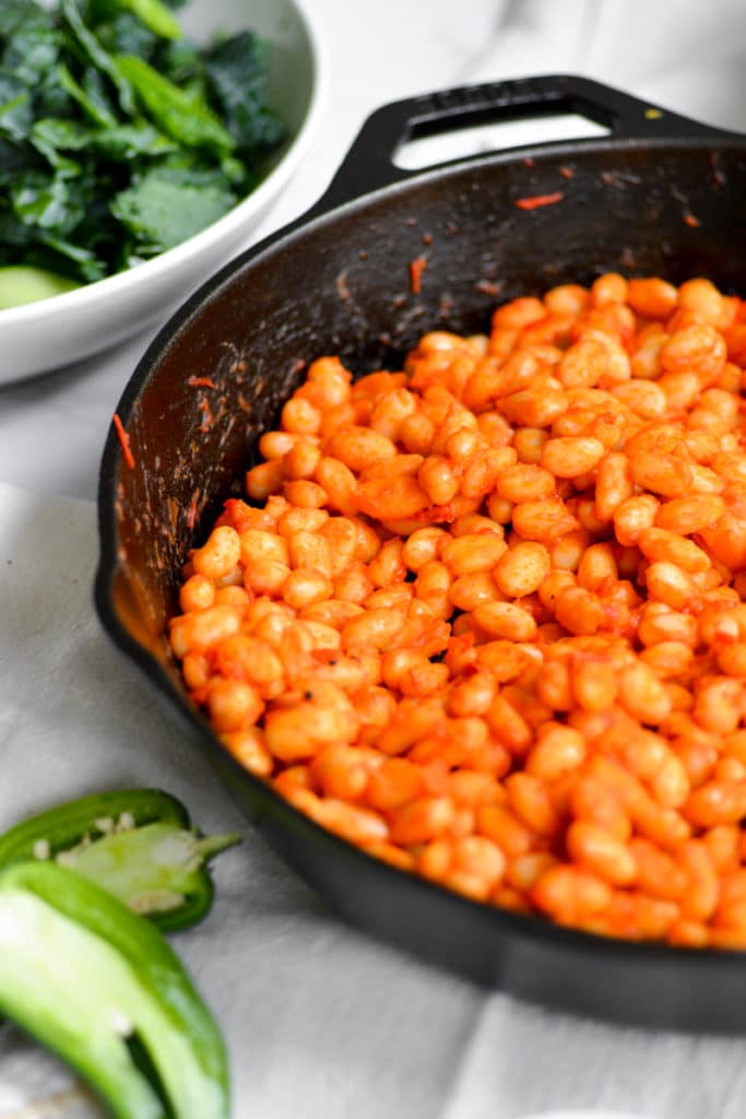 Harissa white beans in a cast iron skillet