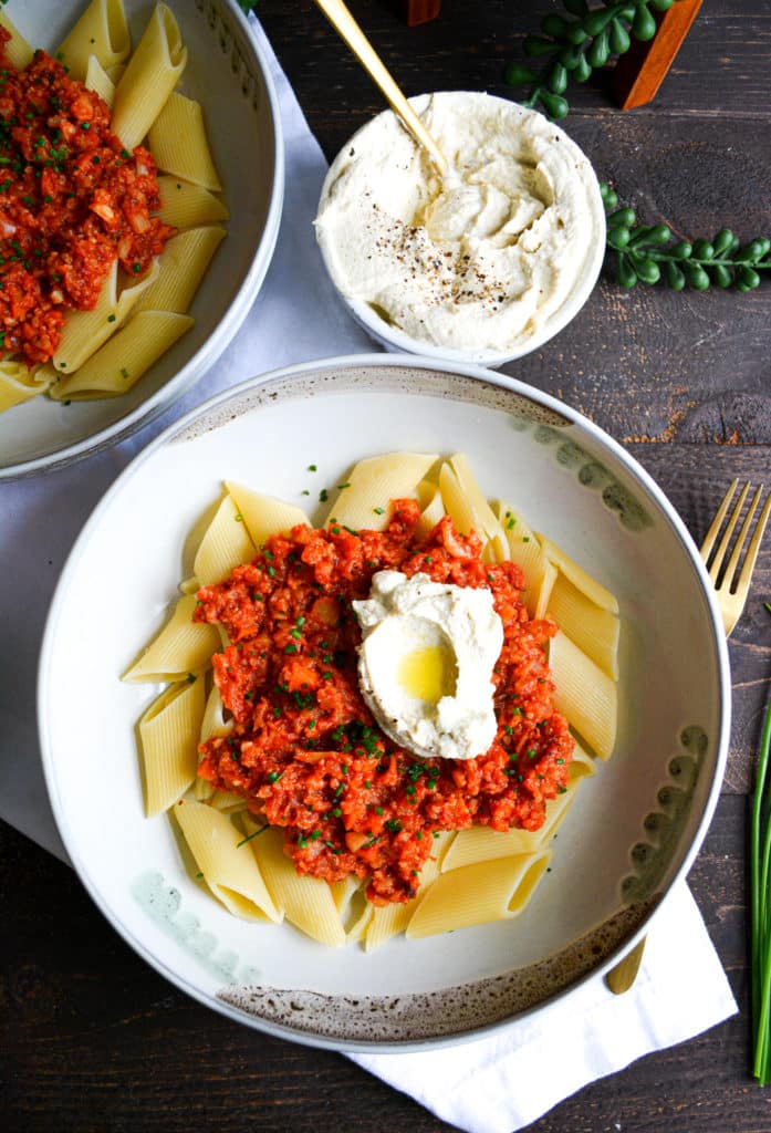 Portraif of pasta in a bowl with sauce and ricotta