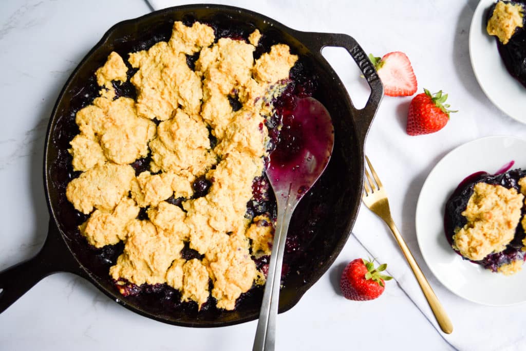 Cornmeal Biscuit Topped Berry Cobbler in a cast iron skillet