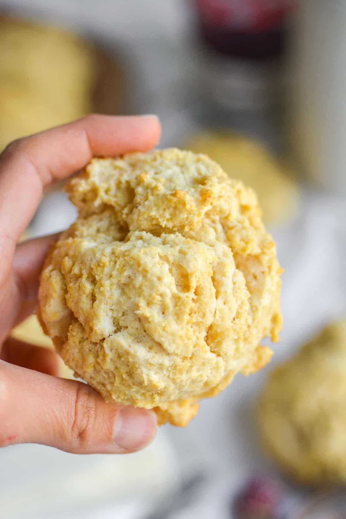 Hand holding a Fluffy Vegan cornmeal drop biscuit