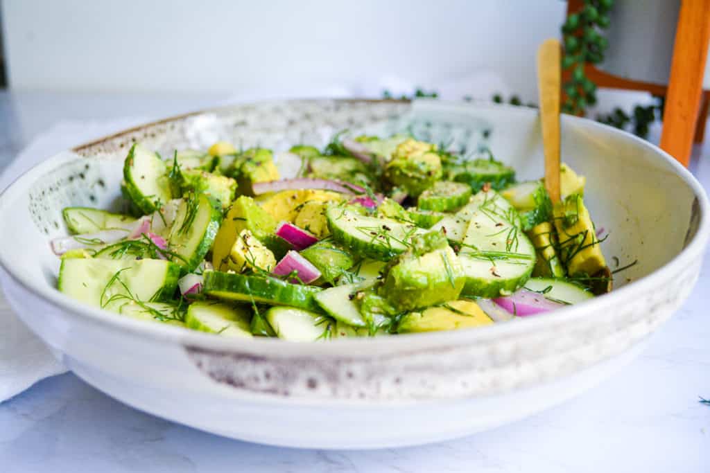 Cucumber and Avocado Salad in a bowl with a gold fork