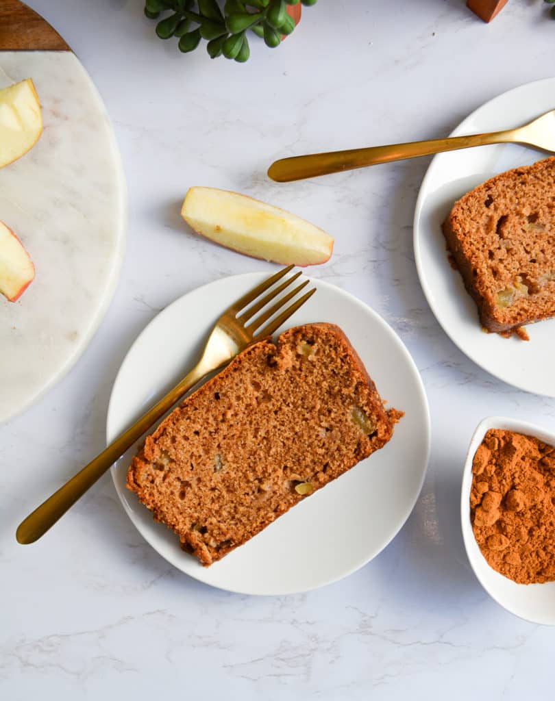 Portrait of Easy Chai Spiced Apple Loaf on a white plate with a gold fork