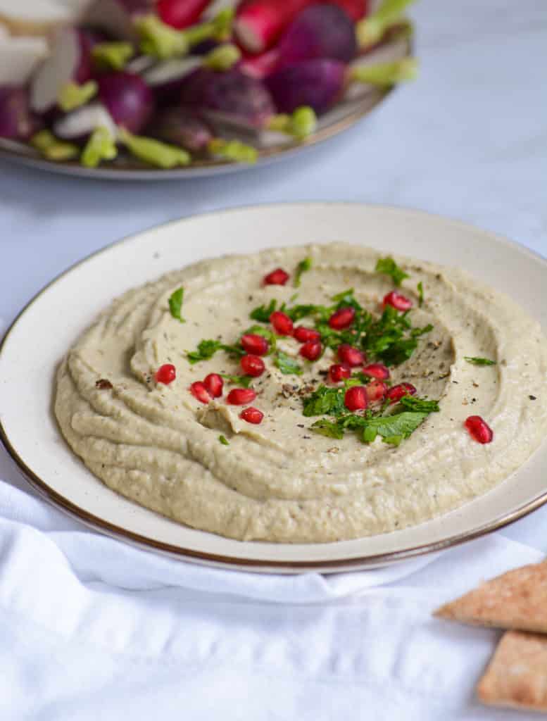Easy and Creamy Baba Ganoush on a plate with pomegranate and parsley