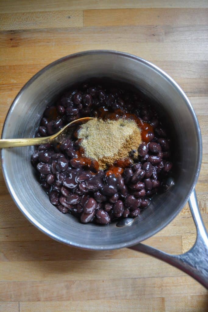 a picture of black beans and spices in a saucepan