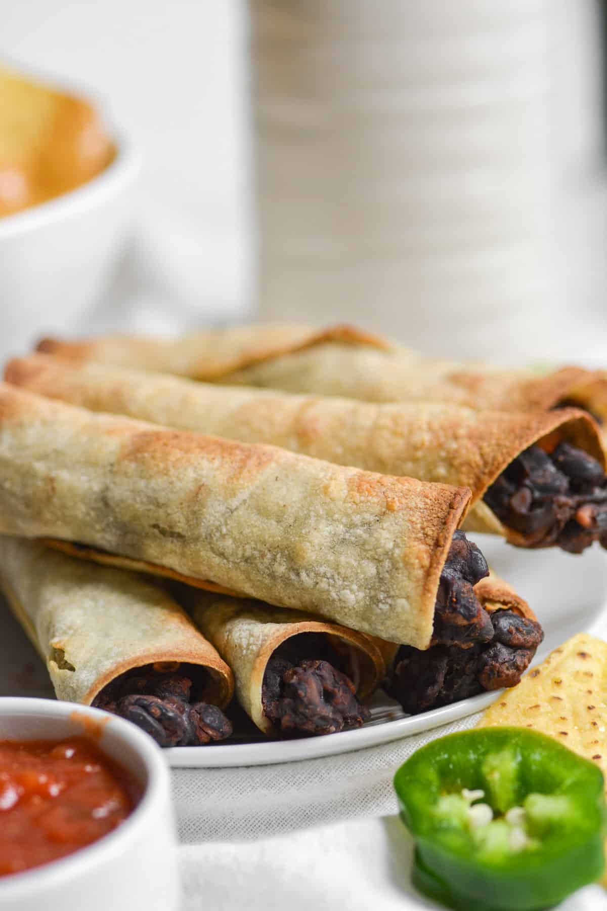 close up of gluten free taquitos on a white plate