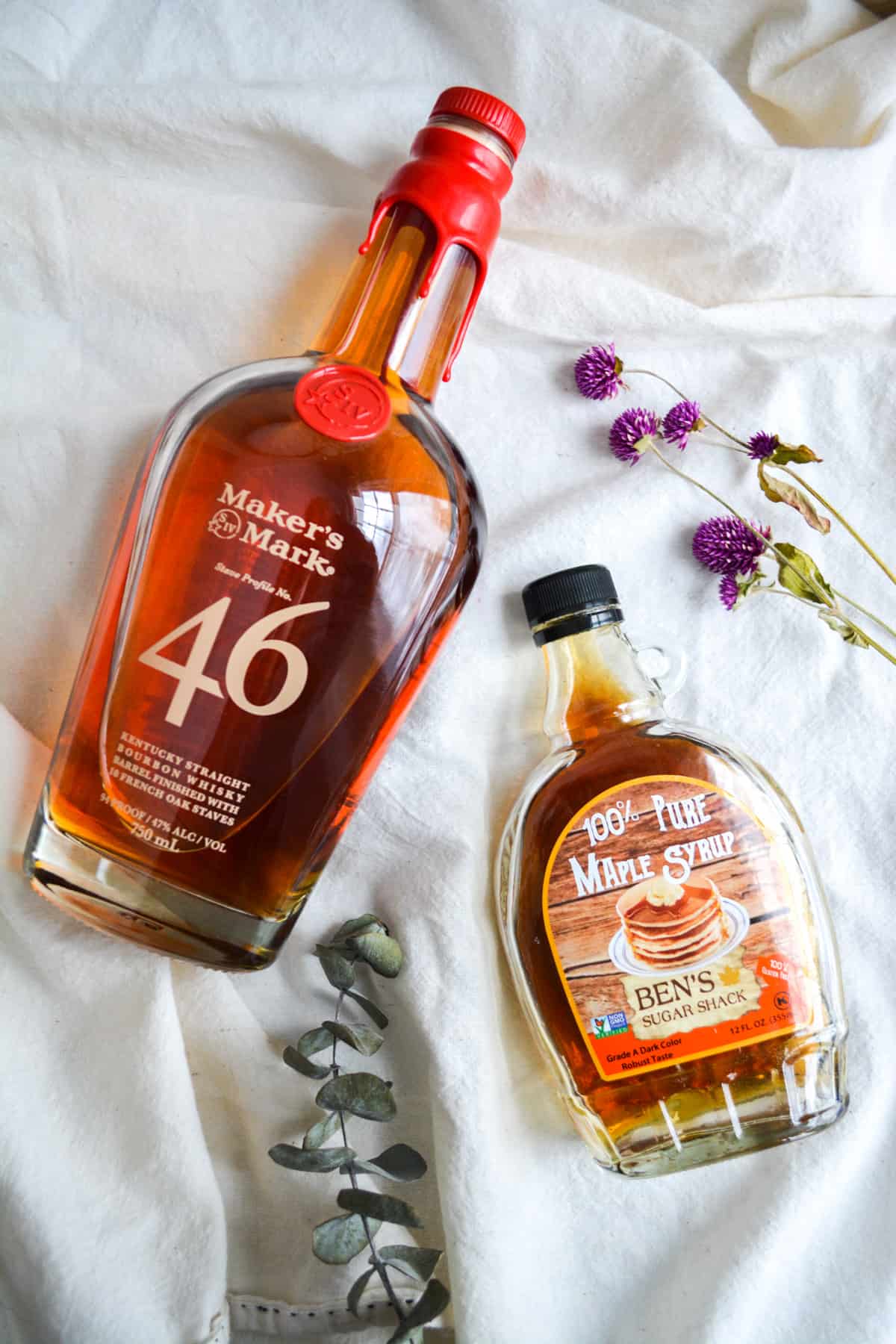 bottles of bourbon and maple syrup on a white cloth