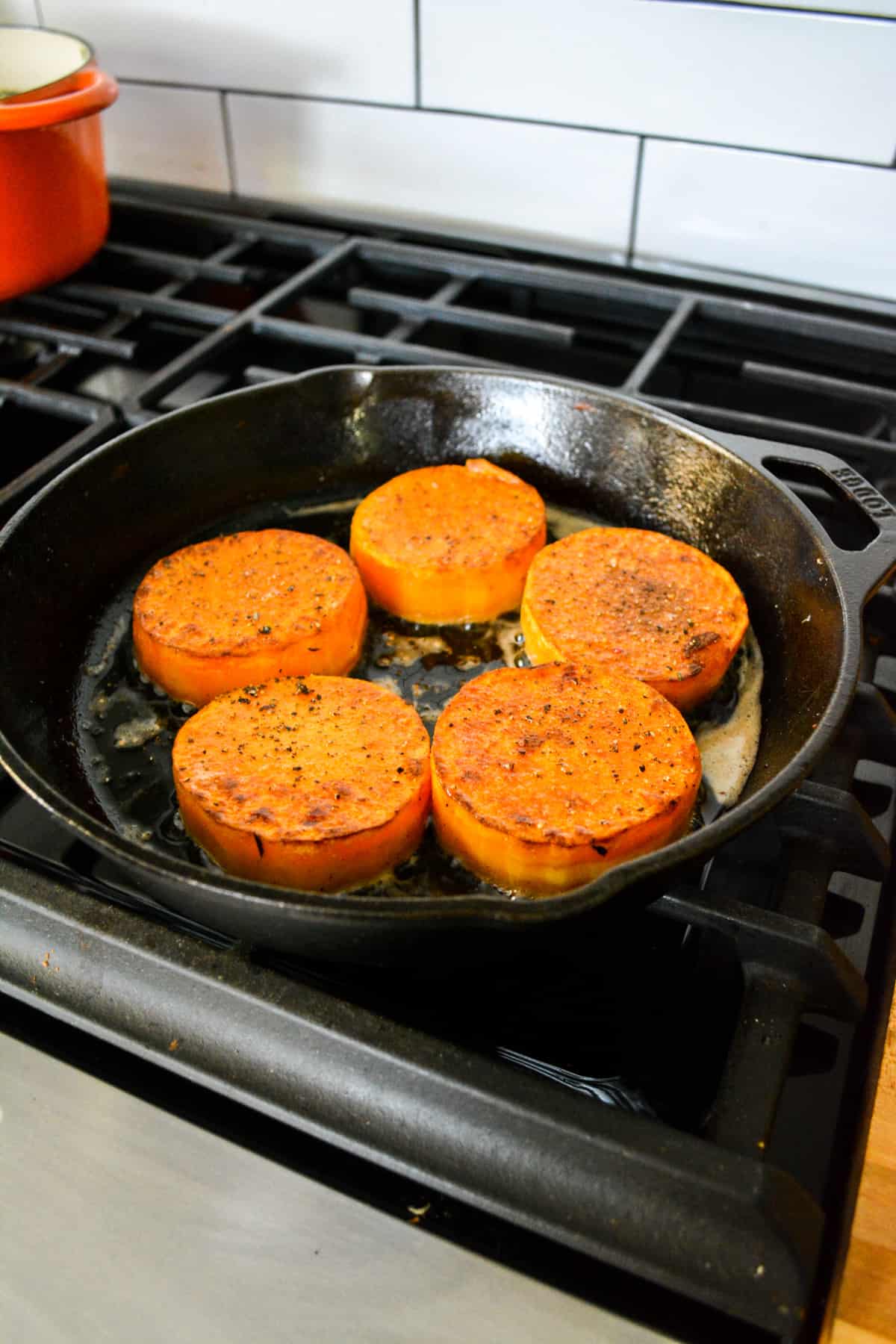 squash steaks searing in a cast iron pan