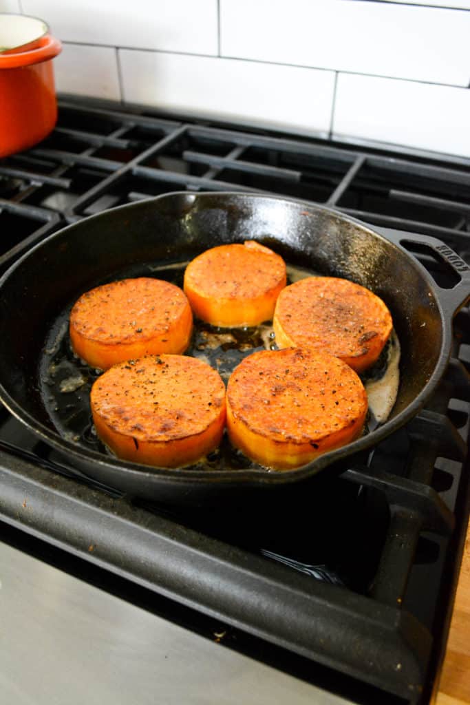 Garlic Butter Butternut Squash Steaks in a cast iron pan