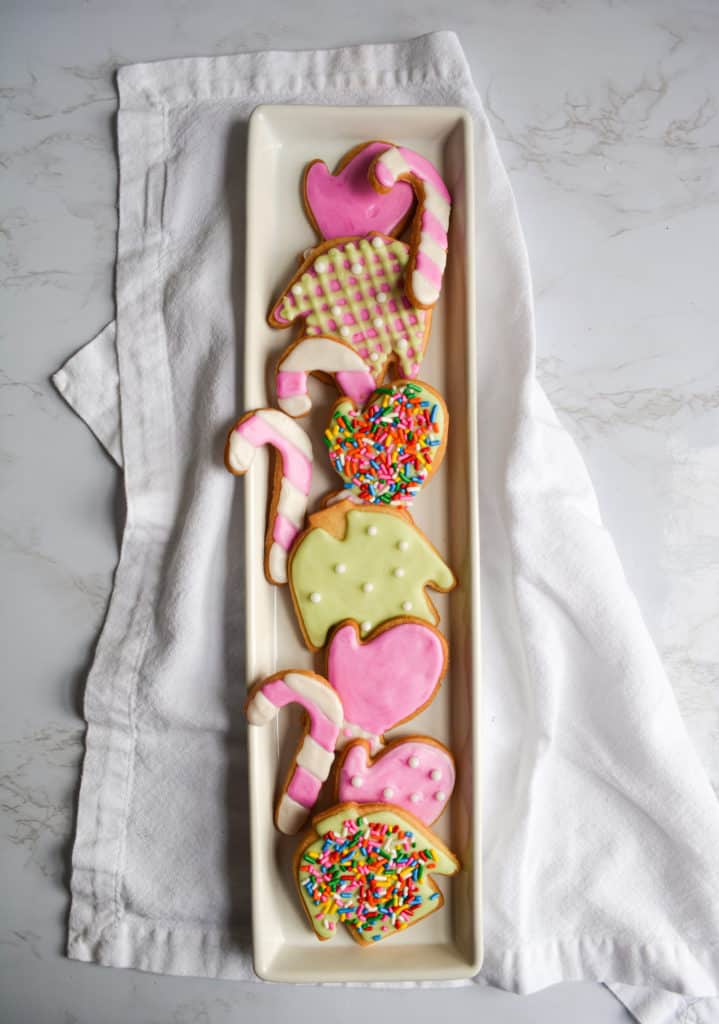 Decorated Vegan Cut-Out Holiday Cookies lined up on a long rectangle plate