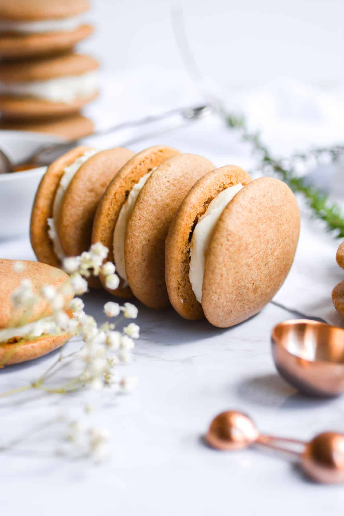 three vegan chai whoopie pies stood up on a marble board