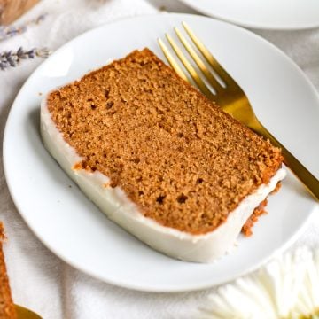 Vegan Gingerbread Loaf Cake on a white plate with a gold fork.
