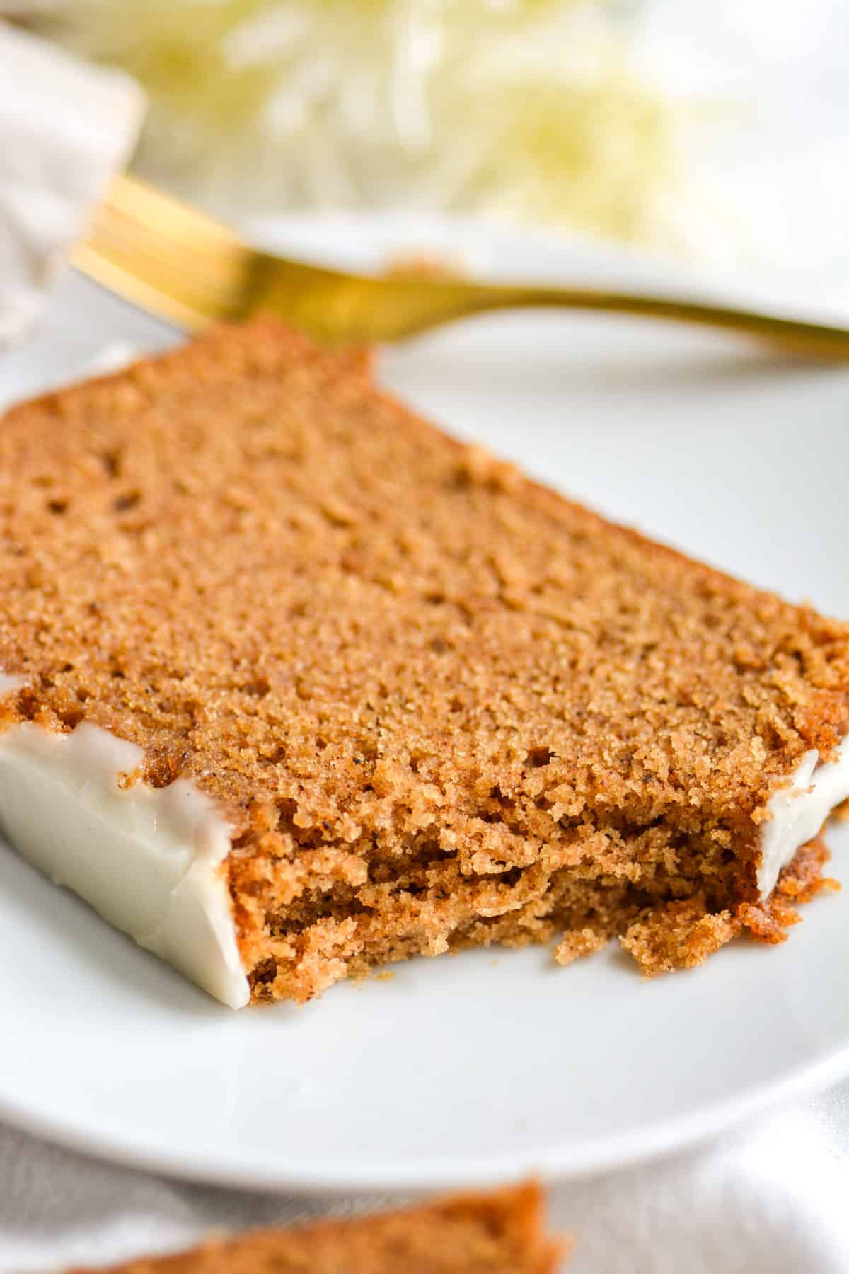 A bite taken out of a slice of vegan gingerbread loaf cake.
