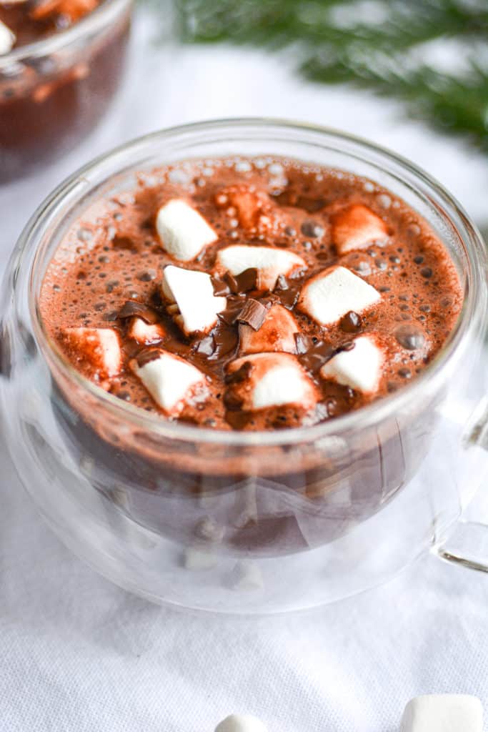 Close up of hot chocolate in a glass mug with marshmallows on top
