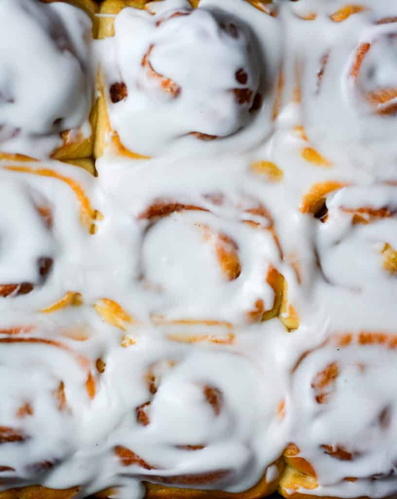 Close up of a pan of cinnamon buns with cream cheese frosting