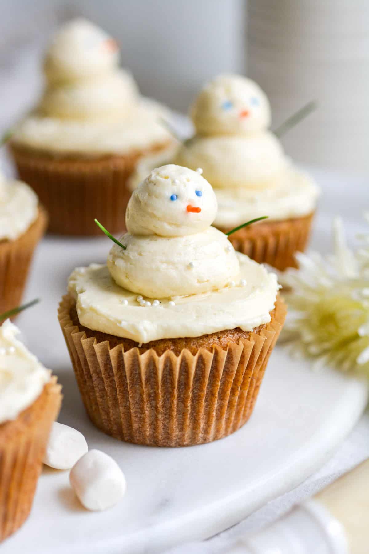 Vegan Gingerbread Cupcakes with buttercream snowmen piped on top of them.