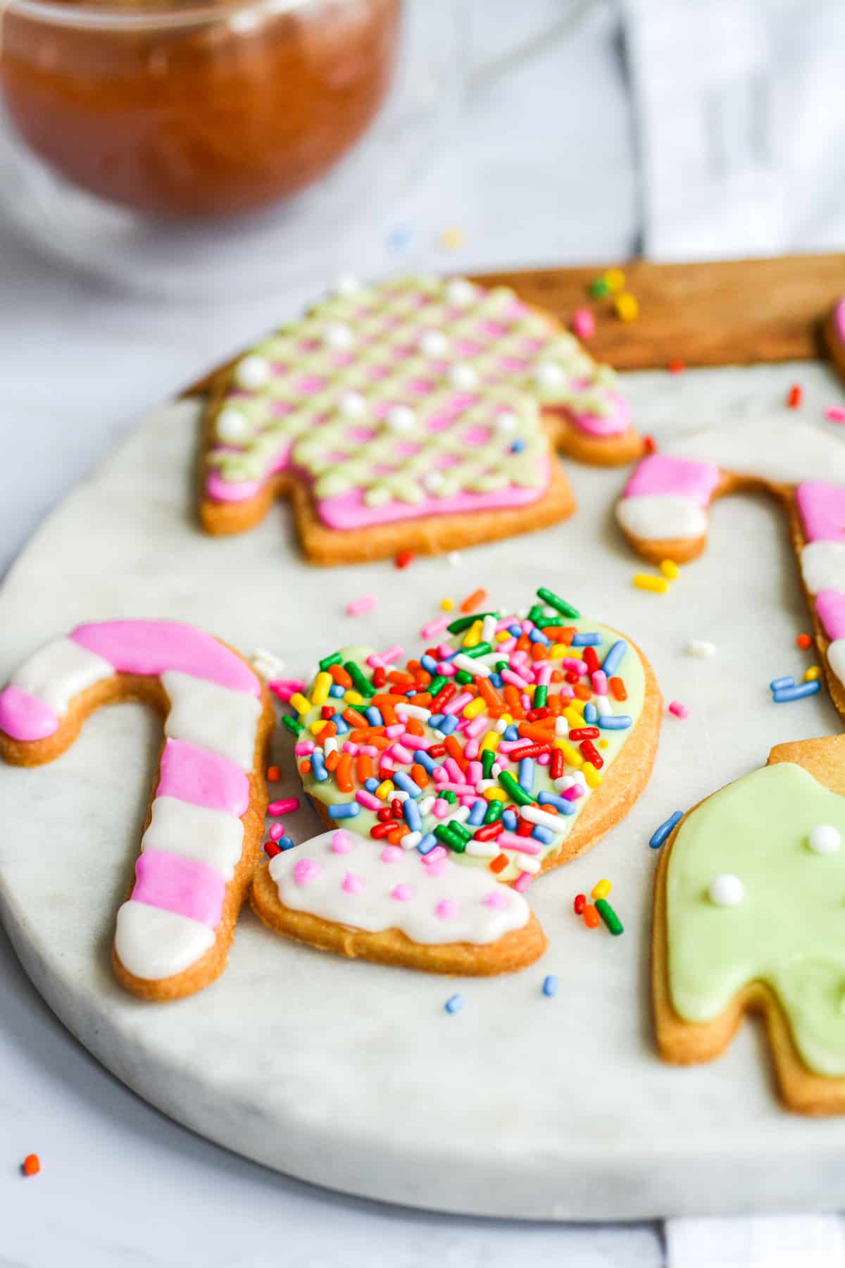 Close up of a vegan holiday cookie that is decorated with sprinkles and icing.