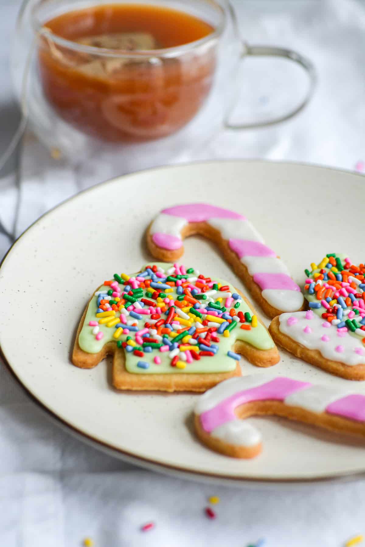 A sweater cookie that is decorated with icing and sprinkles