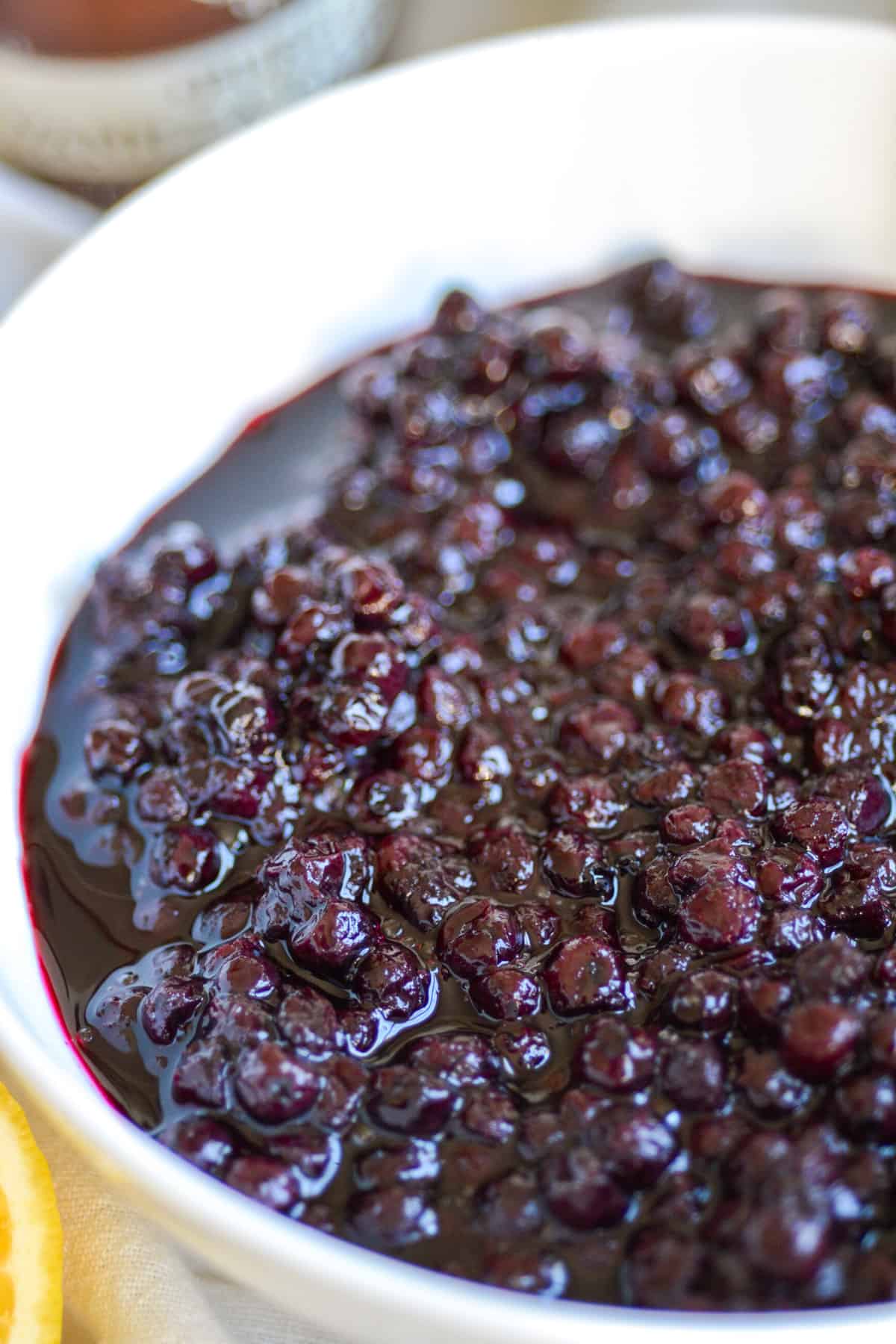 Close up of blueberry compote in a white bowl.