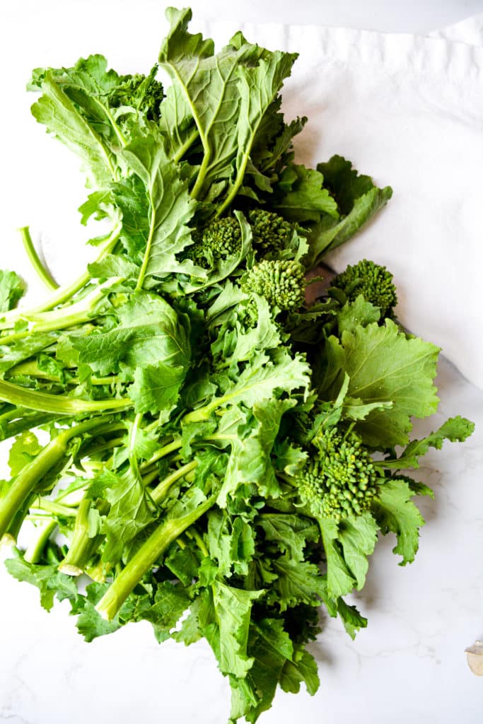 A bunch of broccoli rabe on a marble table