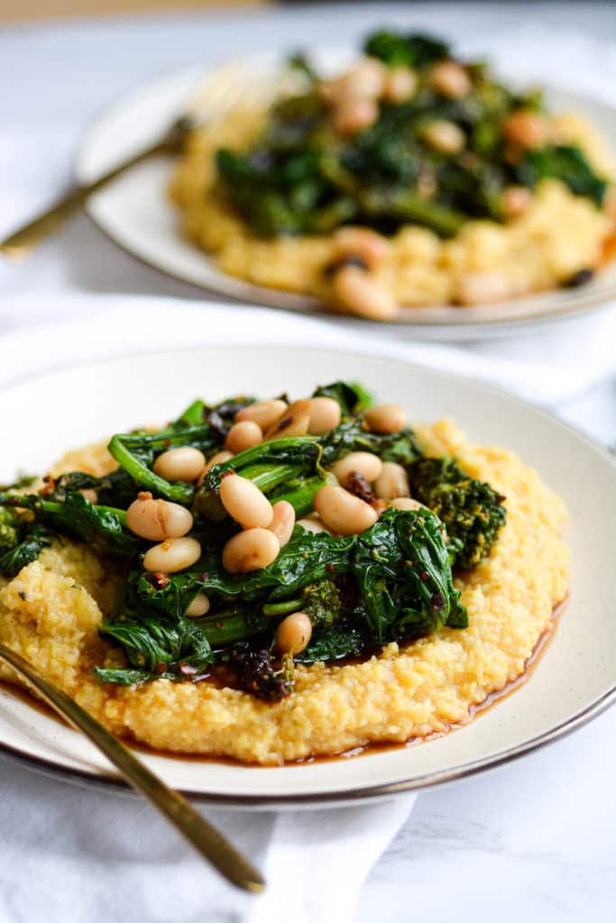 Close up of a plate of polenta with broccoli rabe and white beans