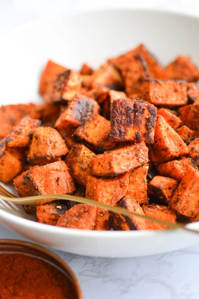 Close up of a white bowl filled with breakfast sweet potatoes