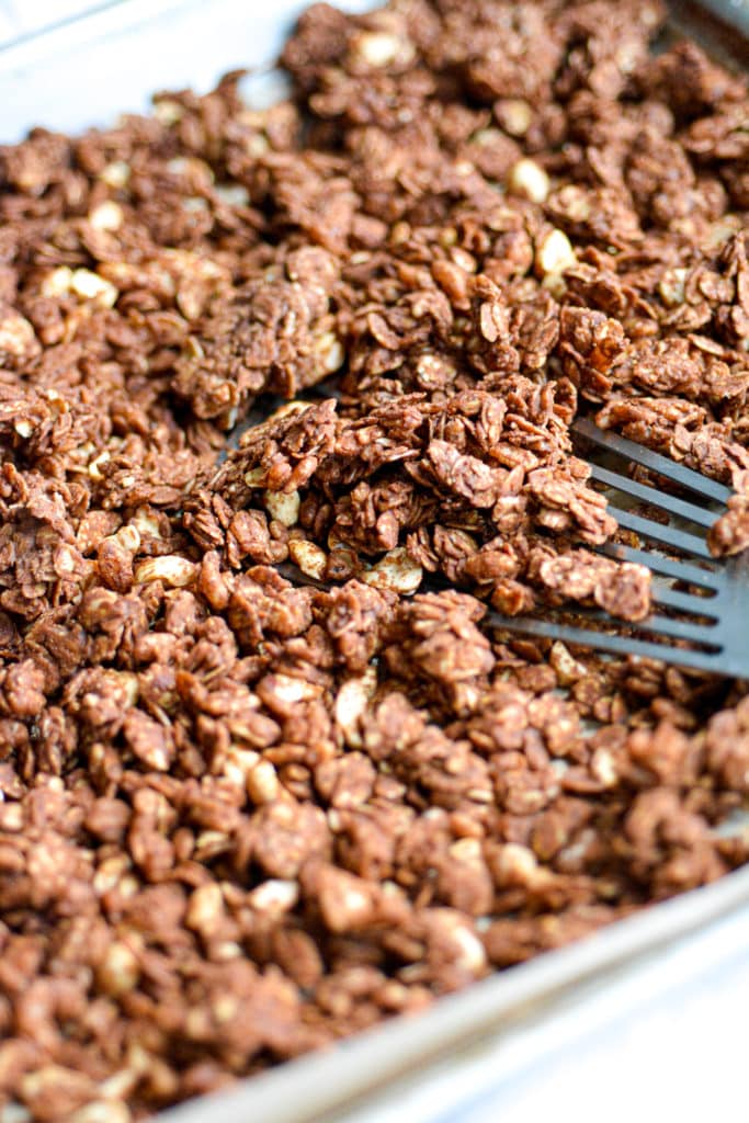Peanut Butter Cup Granola on a pan with a silver spatula