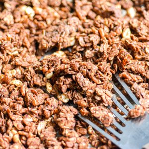 Chocolate Peanut Butter Granola on a sheet pan with a spatula