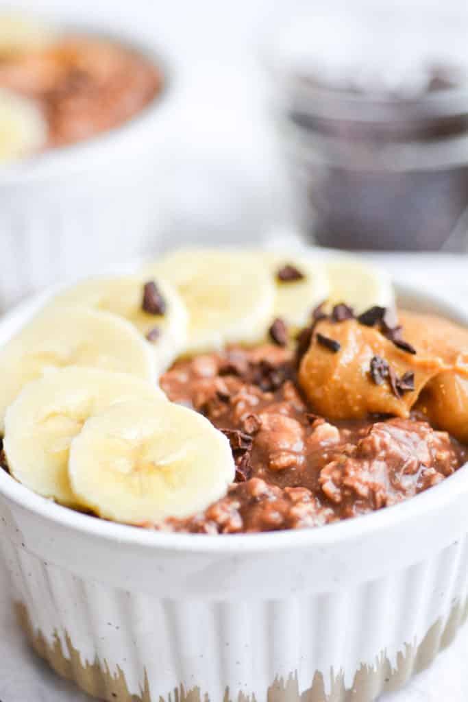 Close up of oats in a ramekin topped with banana 