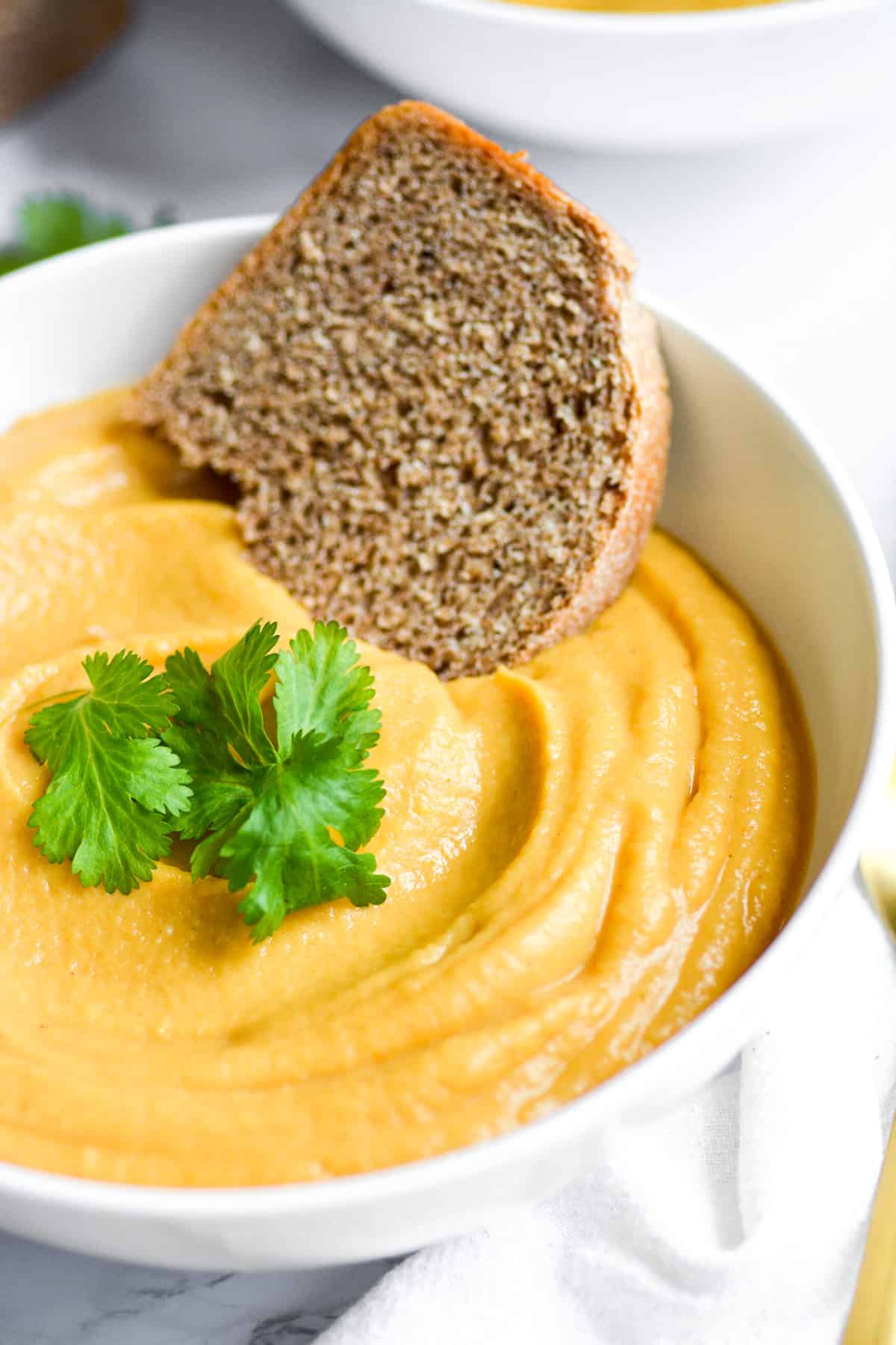 bowl of soup with a piece of bread on the side