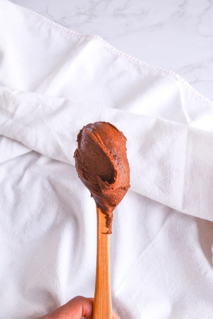 Thickened Chocolate Ganache on a spatula against a white background
