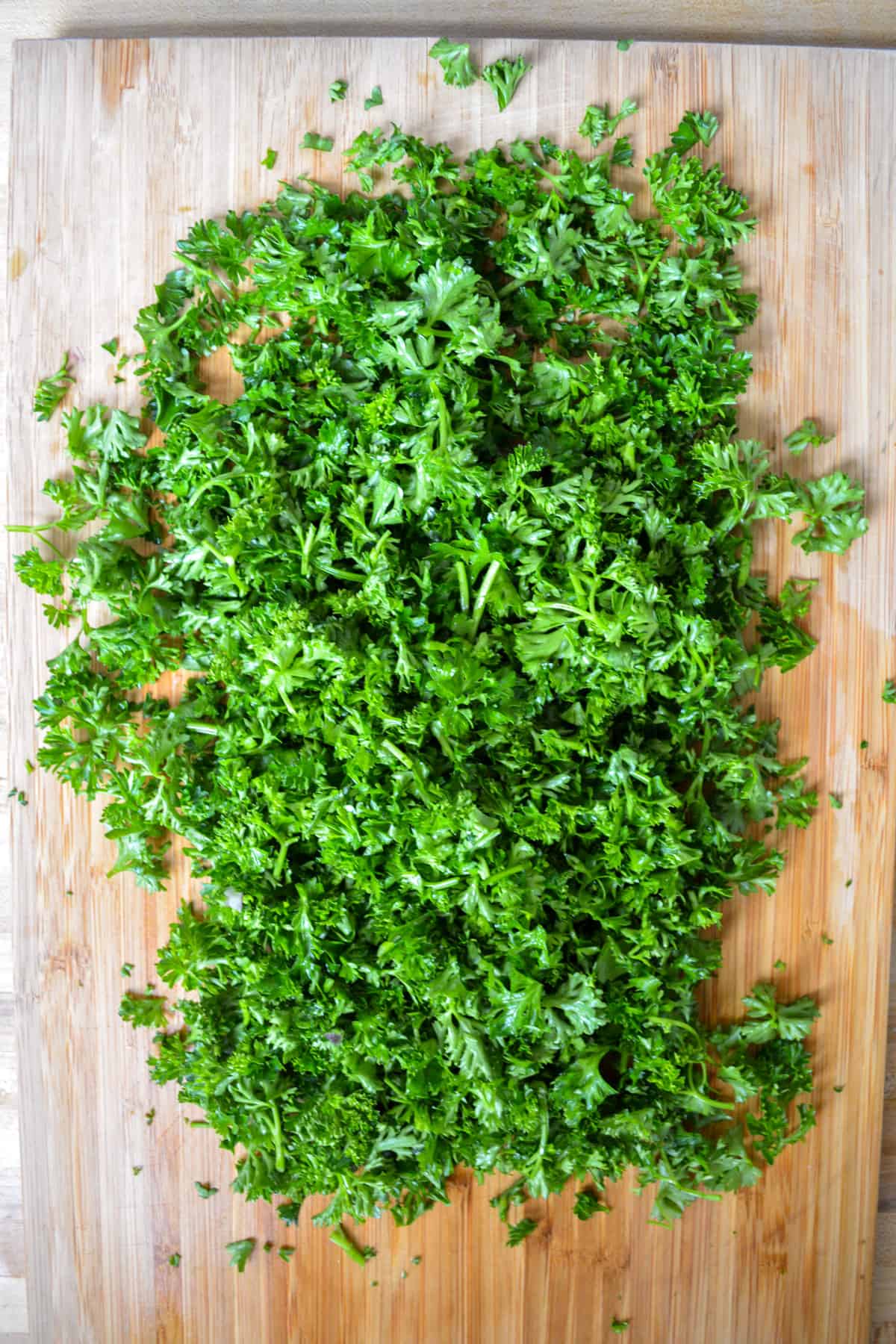 Chopped parsley on a wooden cutting board.