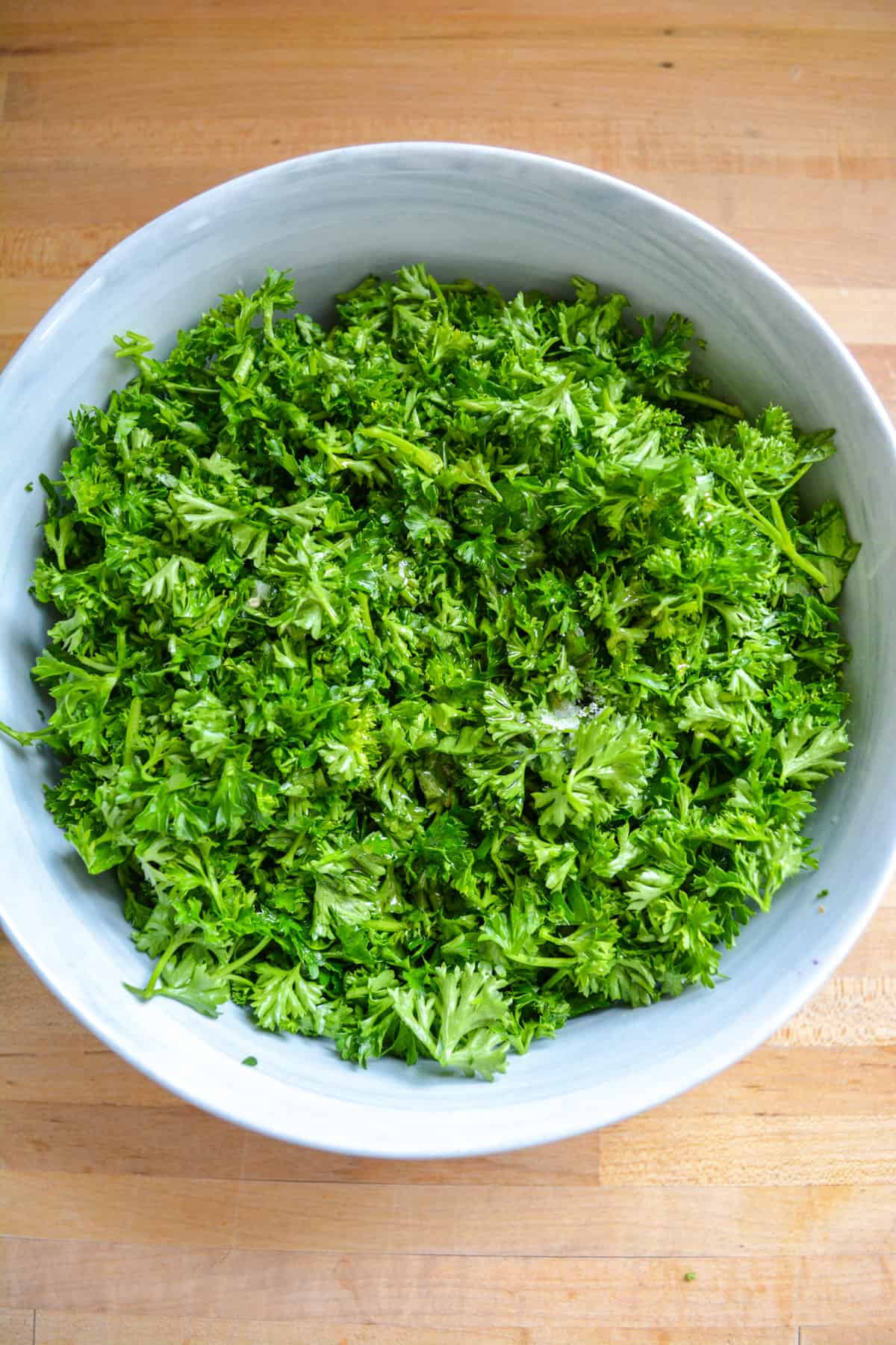 Parsley, lemon juice, olive oil and salt added into the mixing bowl.