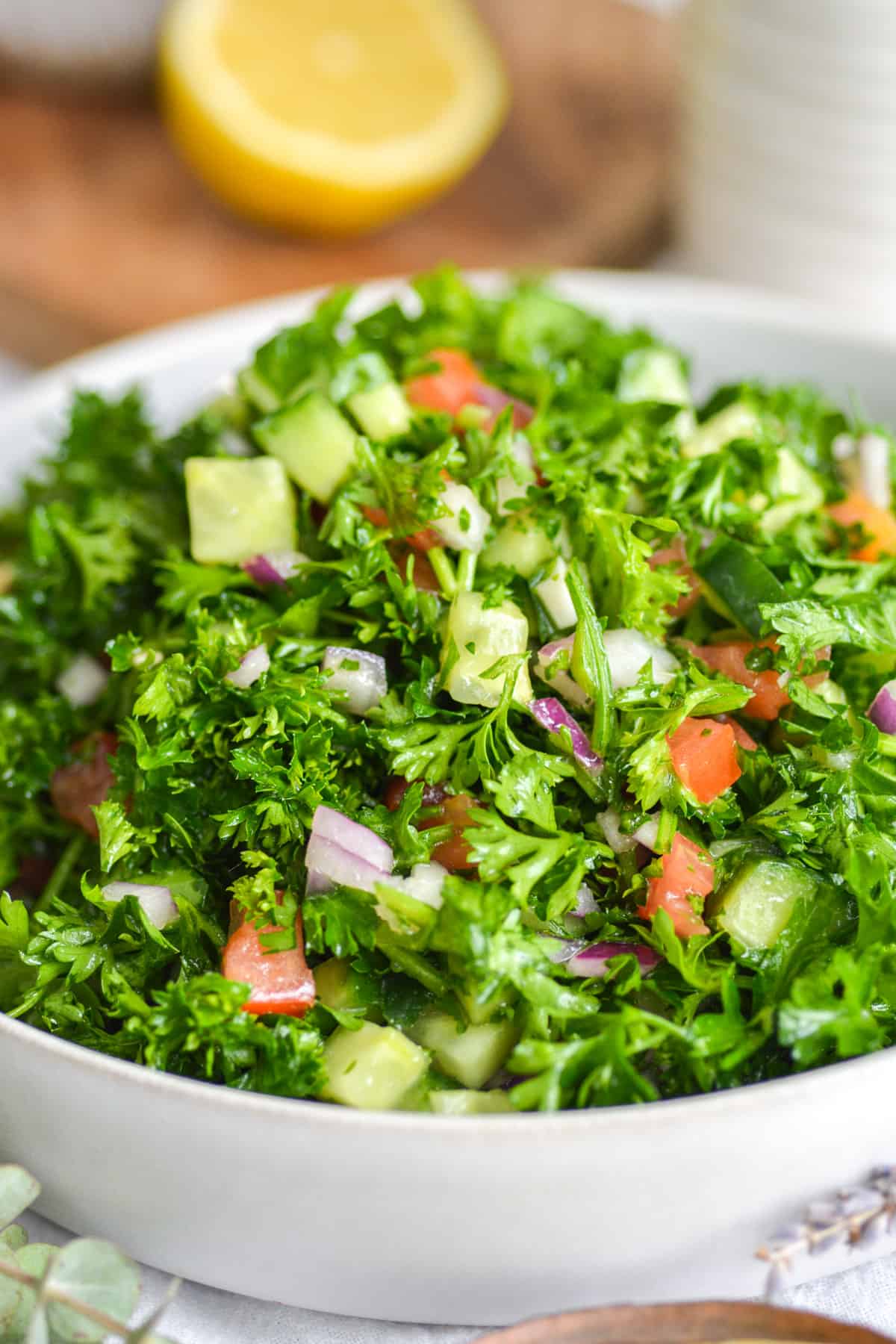 Close up of grain-free tabbouleh salad recipe in a shallow white bowl.