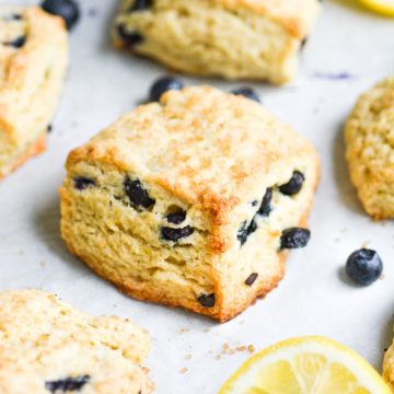 close up of blueberry scone on a baking sheet with a lemon slice