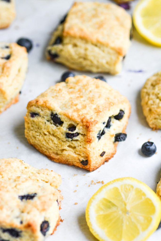 close up of blueberry scone on a baking sheet with a lemon slice