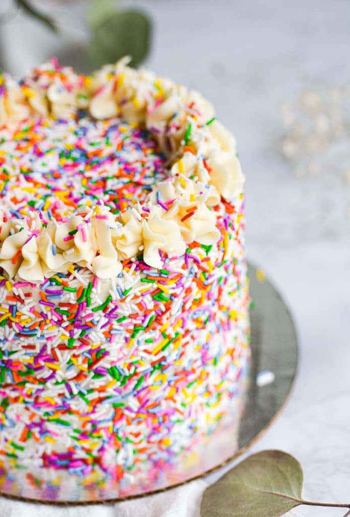 close up of vegan funfetti cake that is covered in sprinkles