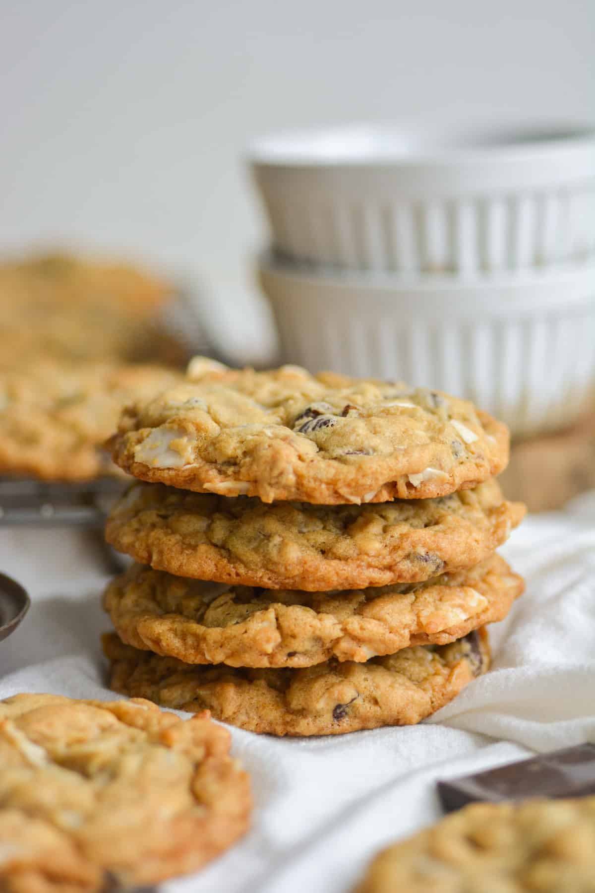 4 Vegan Oatmeal Coconut Chocolate Chip Cookies Stacked on top of each other.