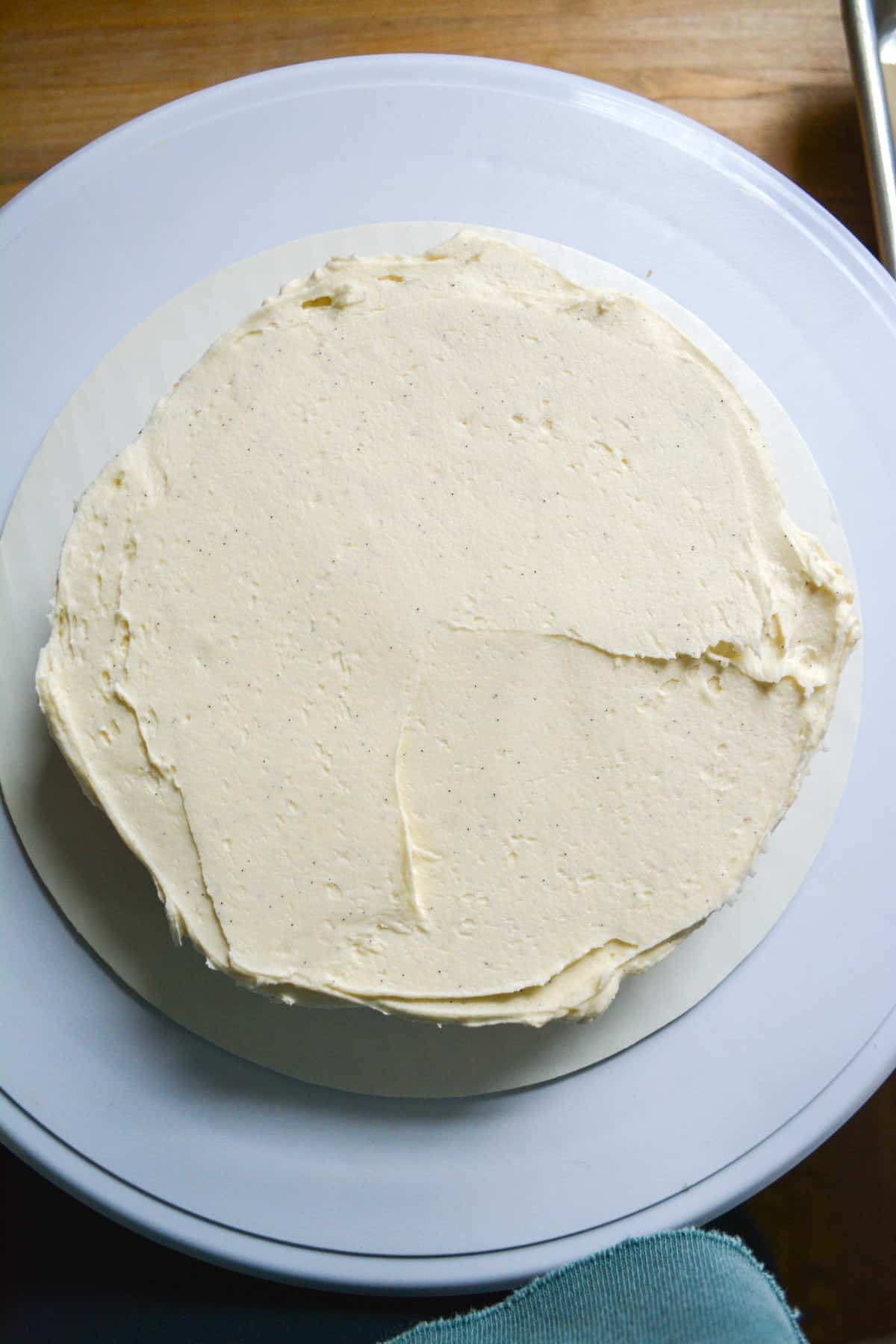 Vanilla frosting spread out on a cake layer.