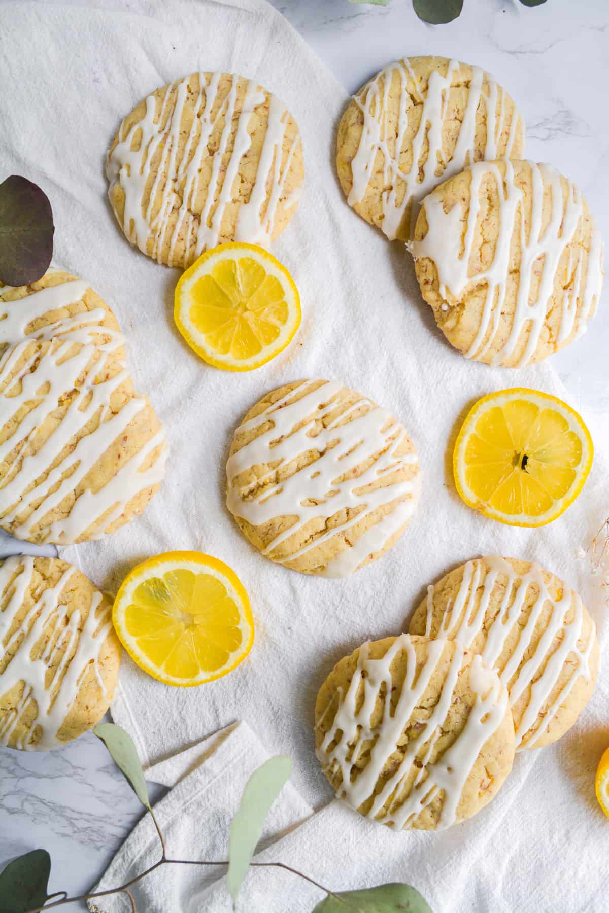 Overhead shot of cookies on a white cloth with slices lemons around it