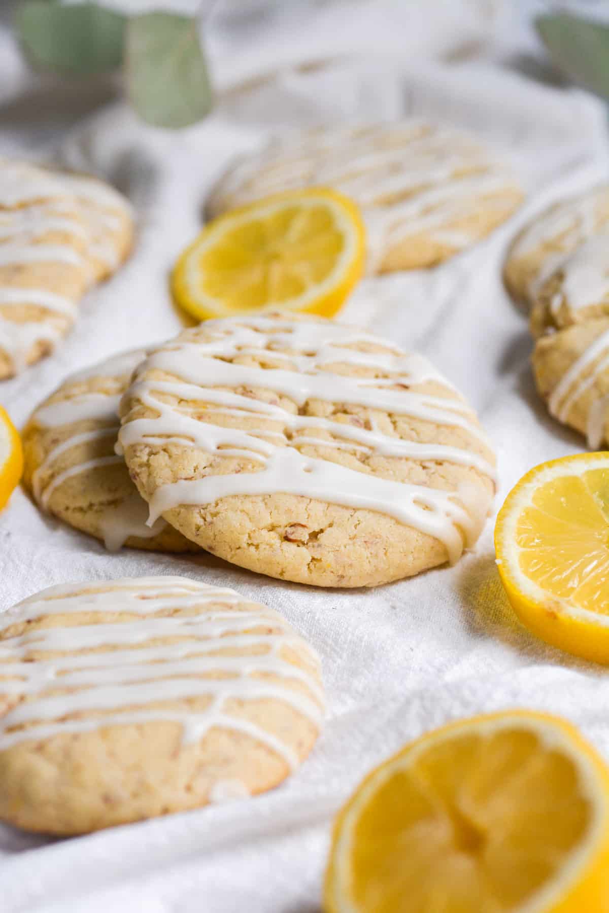 close up of vegan lemon cookies with sliced lemon in the background