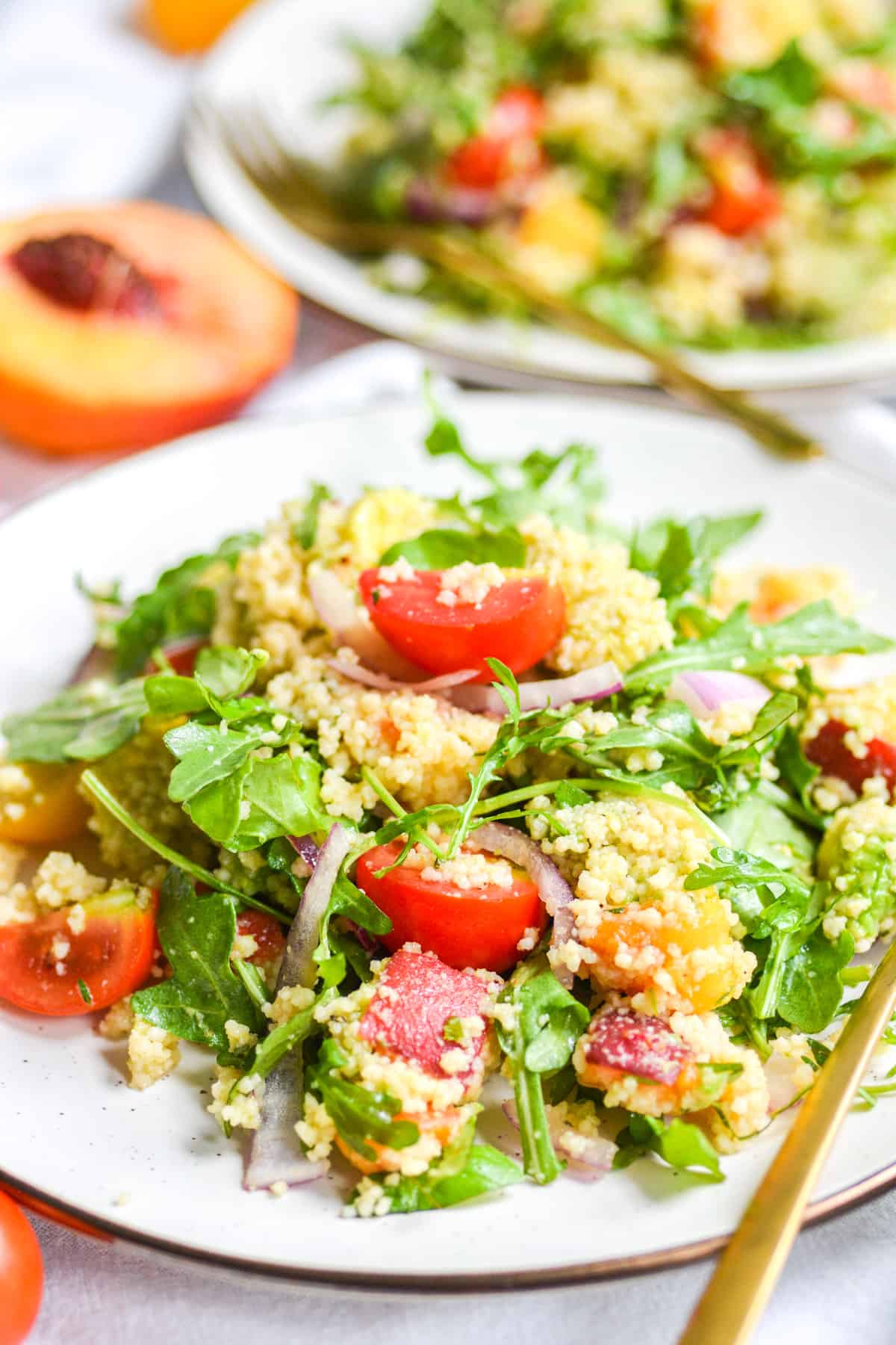 Vegan Couscous salad with nectarine and arugula on a plate