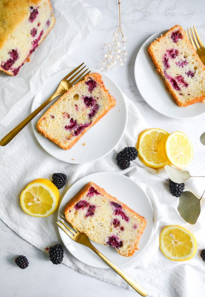 Overhead shot of 3 white plates with slices of Blackberry Lemon Bread