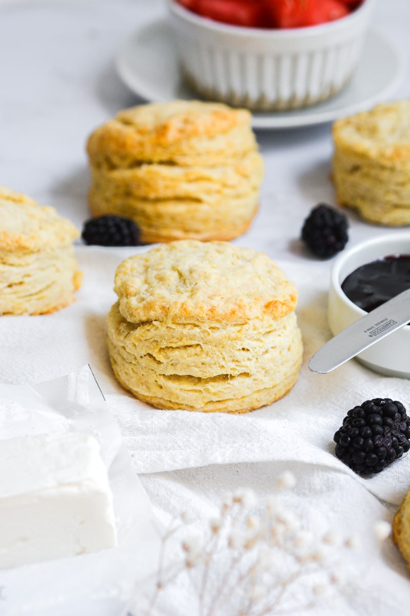 Vegan Buttermilk Biscuits on a white marble board with blackberries scattered about