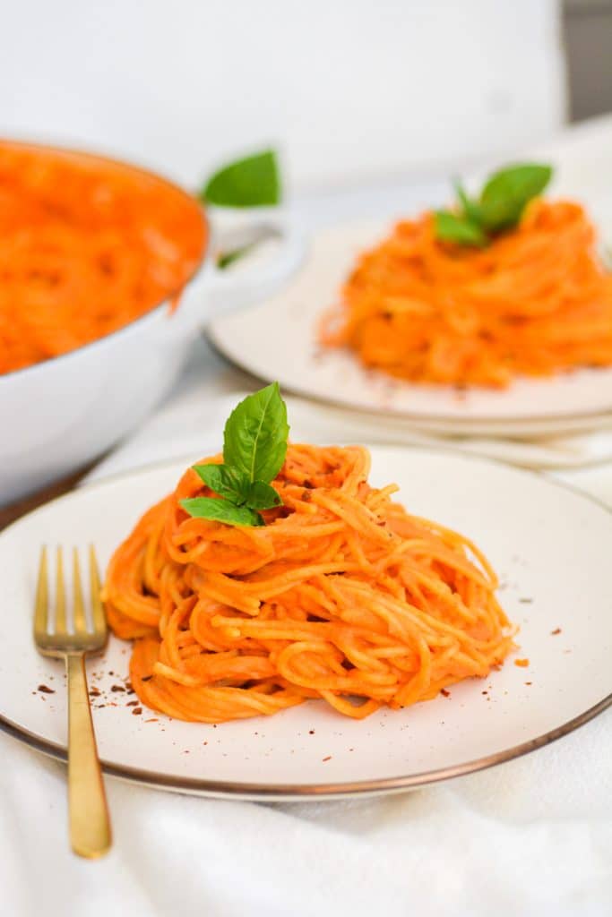 two plates with vegan creamy tomato pasta