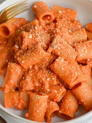 A bowl of Vegan Vodka Sauce and pasta in a bowl with a fork on the top left.